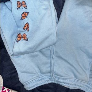 blue sweats with some butterfly’s at the bottom of one of the legs